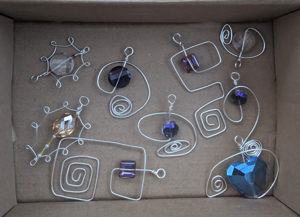 Cardboard box containing Christmas tree decorations made from faceted glass beads and silver wire.