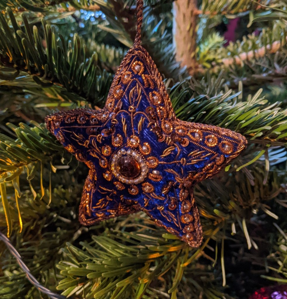 Christmas tree decoration in the shape of a five-pointed star, made from blue velvet and embroidered with beads and copper thread