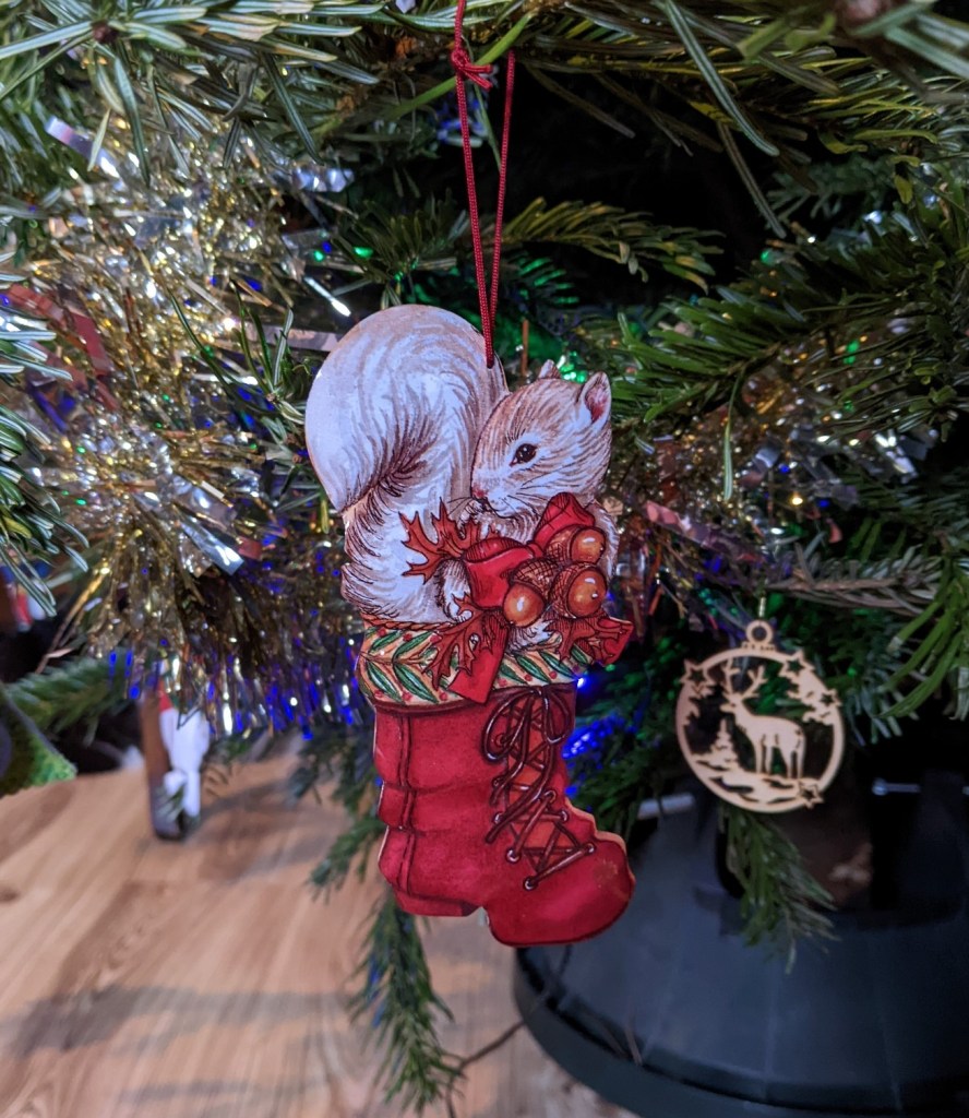Christmas tree decoration representing a squirrel sitting in a red boot