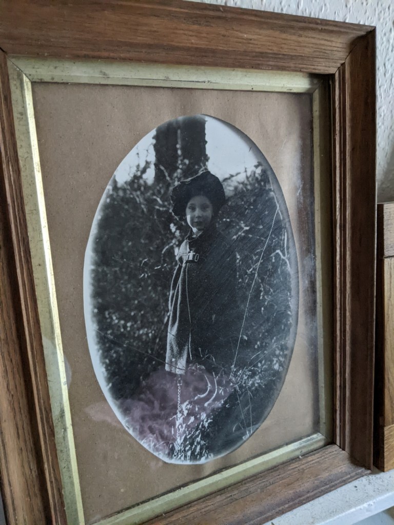 Monochrome photograph of a small child in matching coat and beret