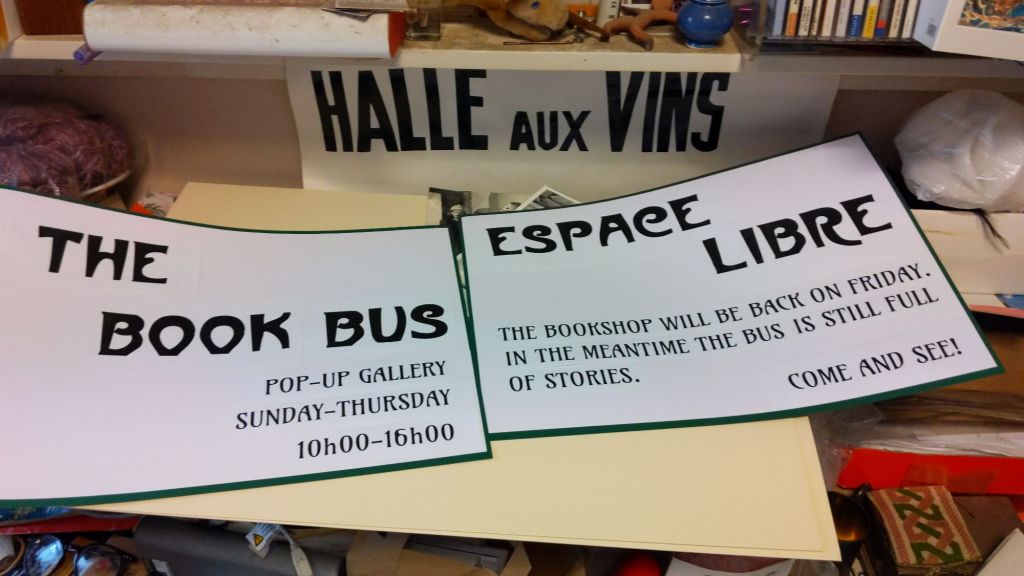 Posters in art nouveau typefaces say:
The Book Bus 
Pop-up gallery 
Sunday -Thursday 10h00-16h00 

Espace Libre 
The bookshop will be back on Friday. In the meantime the bus is still full of stories. Come and see!