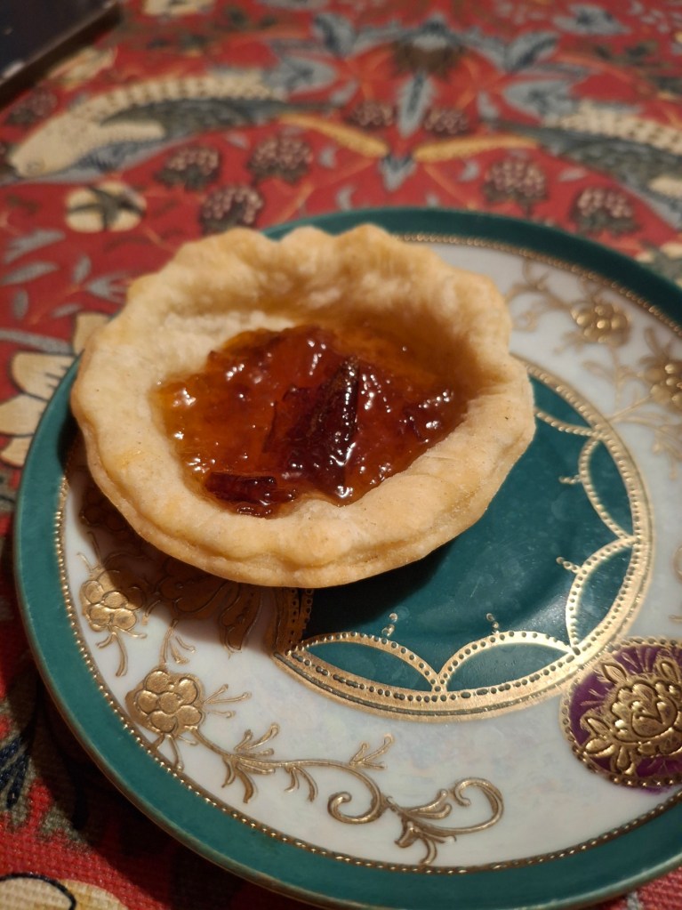 A small jam tart on a small plate