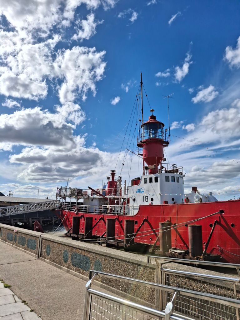 Boat with red hull, white deckhouse, and huge lamp in a red setting
