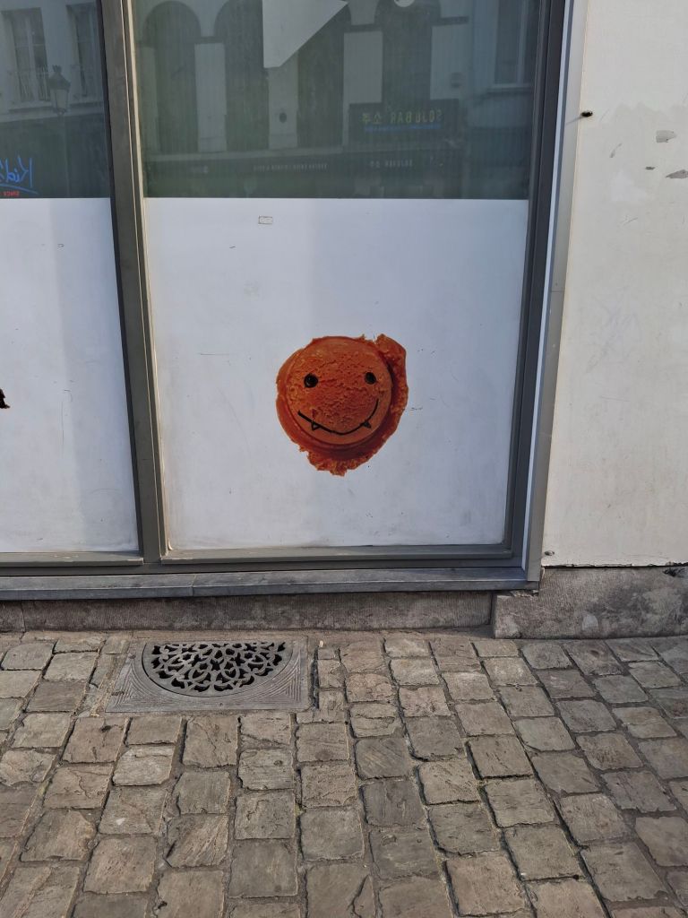 A window transfer with a picture of a scoop of ice cream has been graffitied with a smiley face
